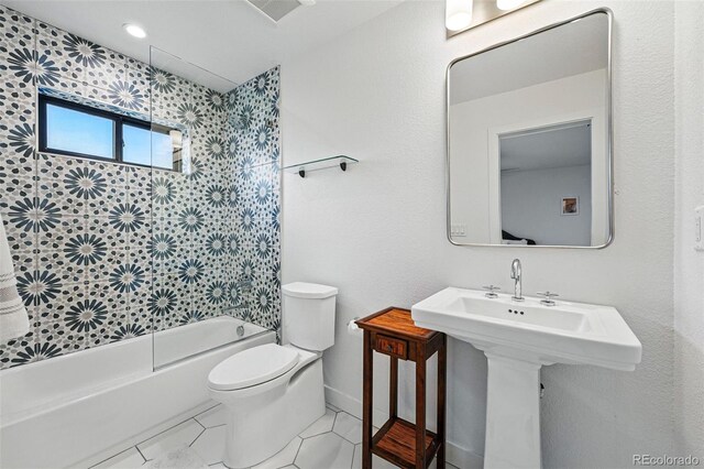 full bath with toilet, tile patterned flooring,  shower combination, baseboards, and a sink
