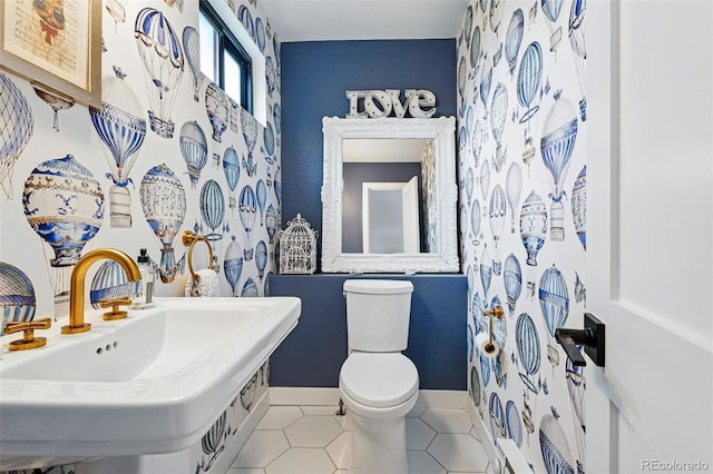 bathroom with tile patterned flooring, toilet, a sink, and baseboards