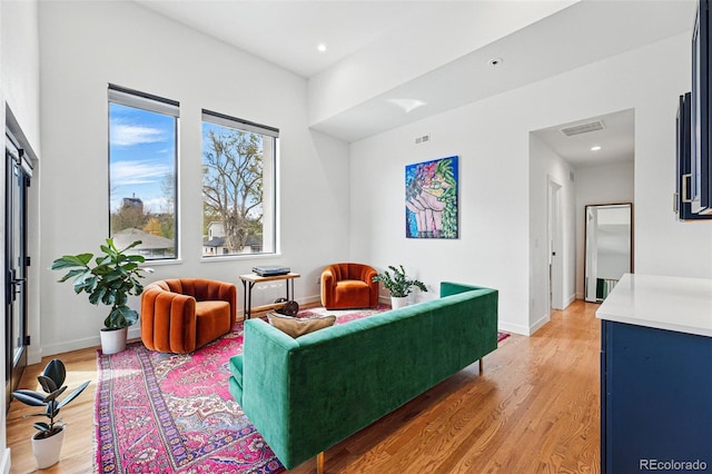 living area with light wood finished floors, baseboards, and recessed lighting
