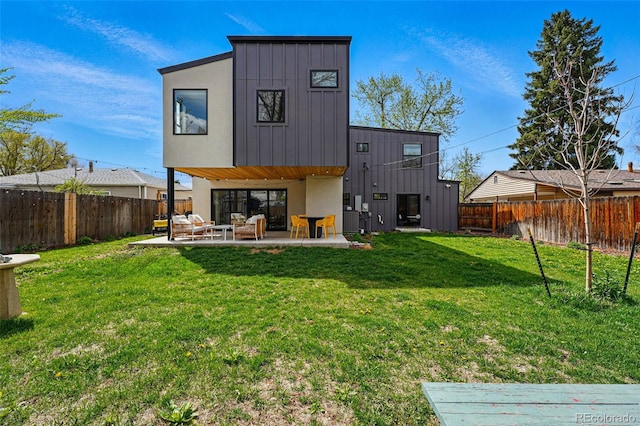 rear view of house with a patio area, board and batten siding, and stucco siding