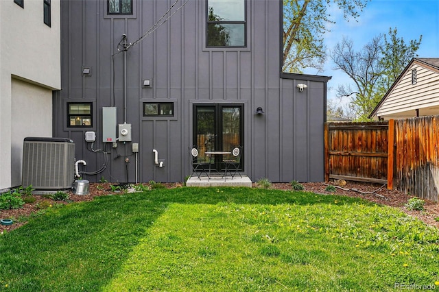 doorway to property featuring board and batten siding and central AC unit