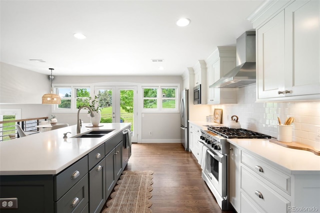 5586 Colorow Dr, Morrison, CO 80465 - kitchen featuring wall chimney exhaust hood, stainless steel appliances, a sink, white cabinets, and light countertops