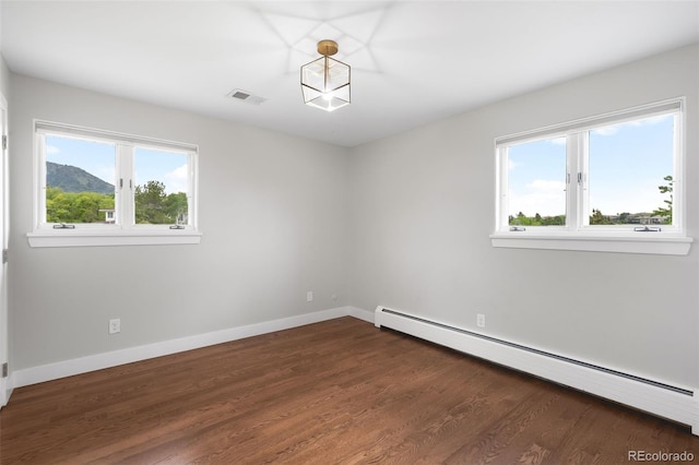 5586 Colorow Dr, Morrison, CO 80465 - empty room featuring a baseboard heating unit, plenty of natural light, baseboards, and dark wood-style floors