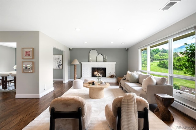 5586 Colorow Dr, Morrison, CO 80465 - living area with a baseboard heating unit, baseboards, dark wood-type flooring, recessed lighting, and a brick fireplace