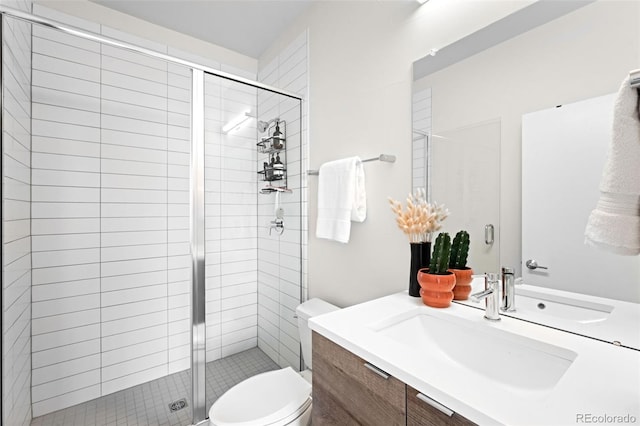 bathroom featuring vanity, an enclosed shower, and toilet