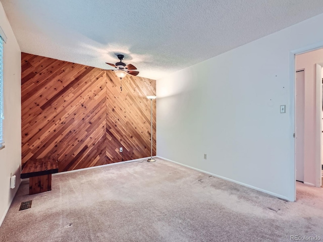 1576 S Ursula Ct, Aurora, CO 80012 - unfurnished living room with a ceiling fan, wood walls, carpet flooring, and a textured ceiling
