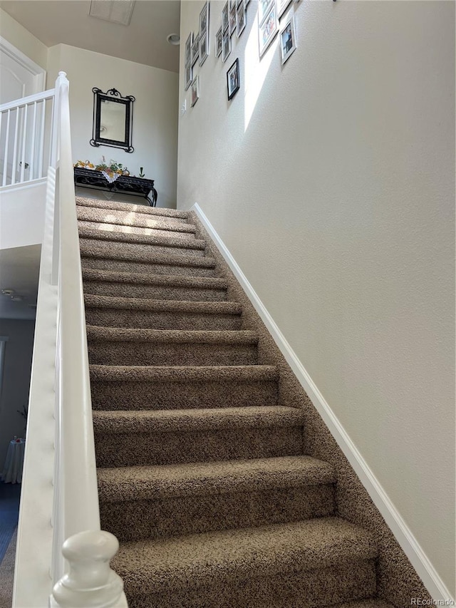 stairway featuring carpet flooring