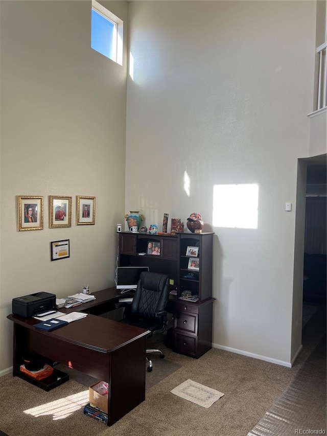 office area featuring a towering ceiling and carpet floors