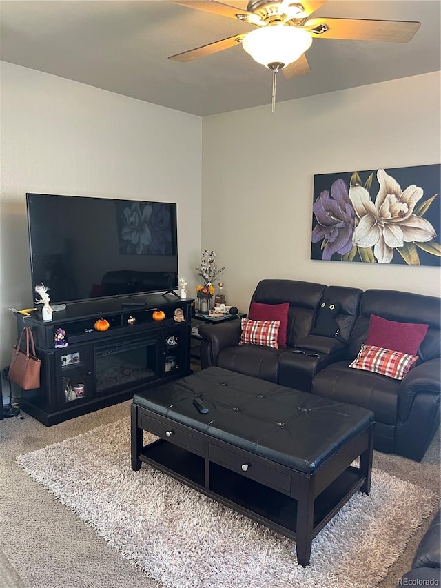 carpeted living room featuring ceiling fan and a fireplace