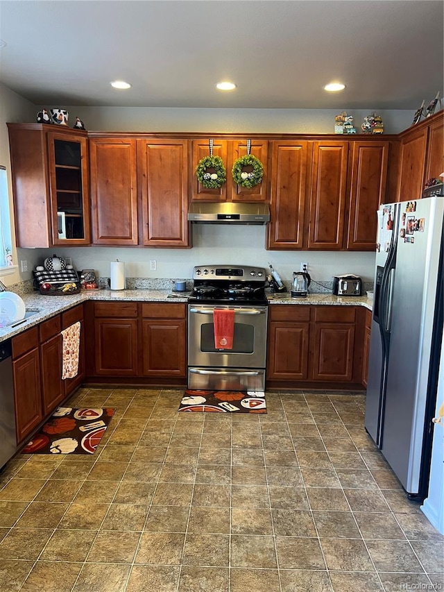 kitchen with stainless steel appliances, sink, and light stone counters