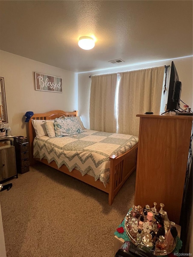 bedroom with a textured ceiling and carpet flooring