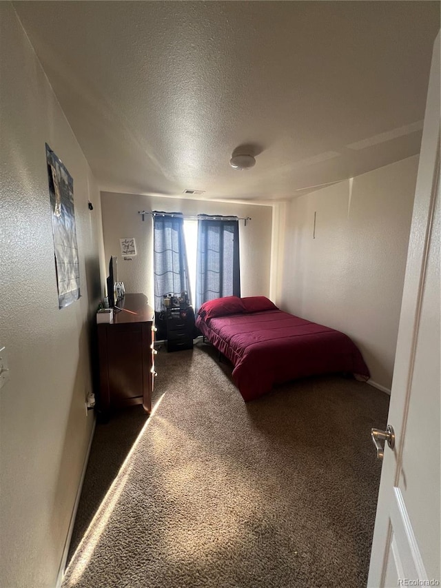 carpeted bedroom featuring a textured ceiling