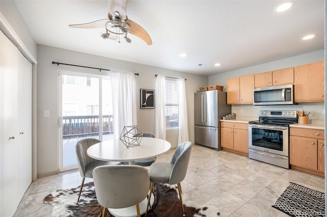 kitchen with appliances with stainless steel finishes, ceiling fan, and light brown cabinetry