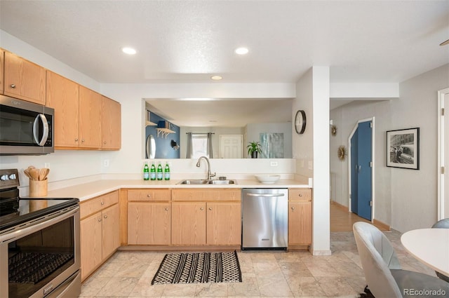 kitchen with kitchen peninsula, appliances with stainless steel finishes, light brown cabinets, and sink