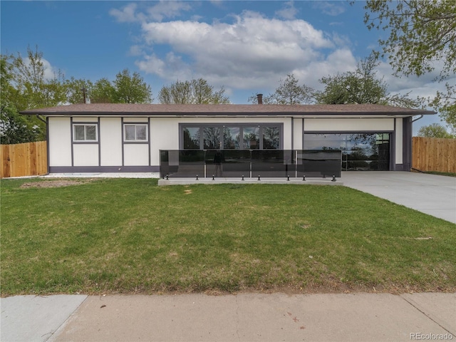 view of front of home featuring a garage, fence, a front lawn, and stucco siding