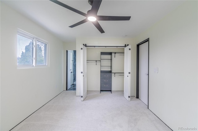 unfurnished bedroom with light carpet, a closet, and a ceiling fan