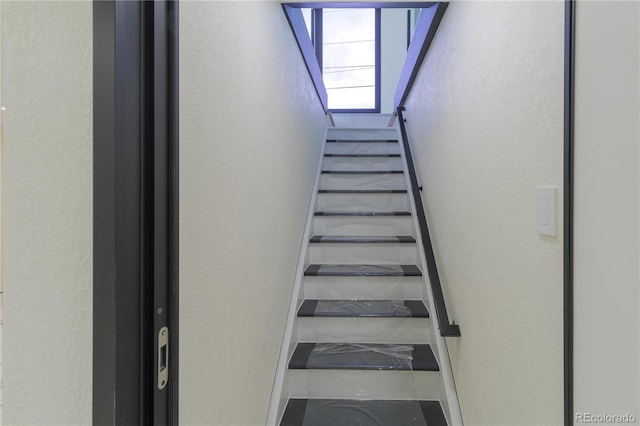 staircase with a textured wall