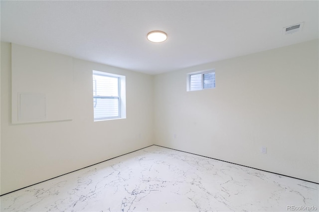 unfurnished room with visible vents