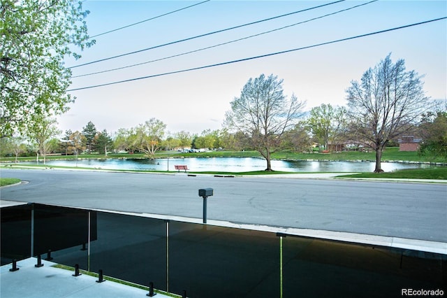 view of road with curbs and a water view