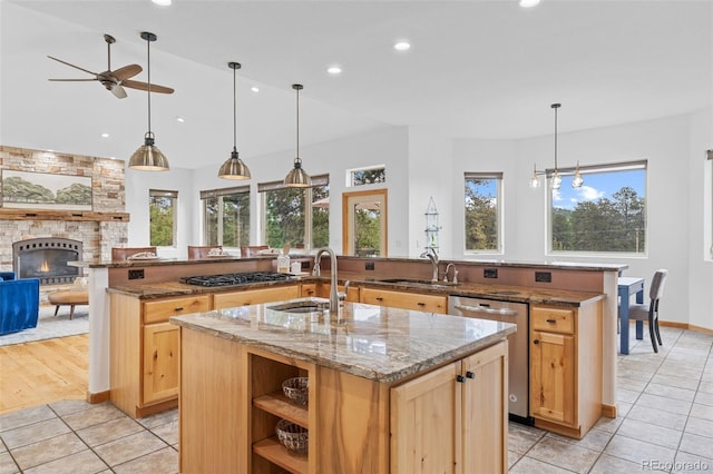 1474 Belford Ct, Evergreen, CO 80439 - kitchen with a center island with sink, stainless steel appliances, ceiling fan, a fireplace, and light tile patterned floors