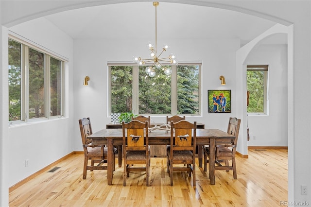 1474 Belford Ct, Evergreen, CO 80439 - dining space featuring arched walkways, light wood-type flooring, and a chandelier