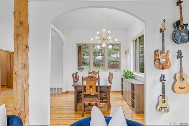 1474 Belford Ct, Evergreen, CO 80439 - dining space with arched walkways, light wood finished floors, and a chandelier