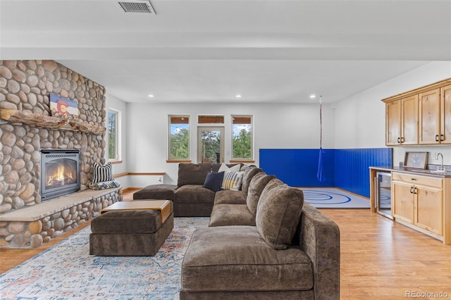 1474 Belford Ct, Evergreen, CO 80439 - living area with wine cooler, light wood-type flooring, a fireplace, recessed lighting, and bar area