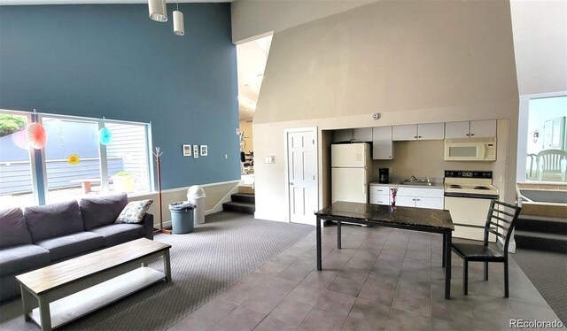 living room with stairs and a high ceiling