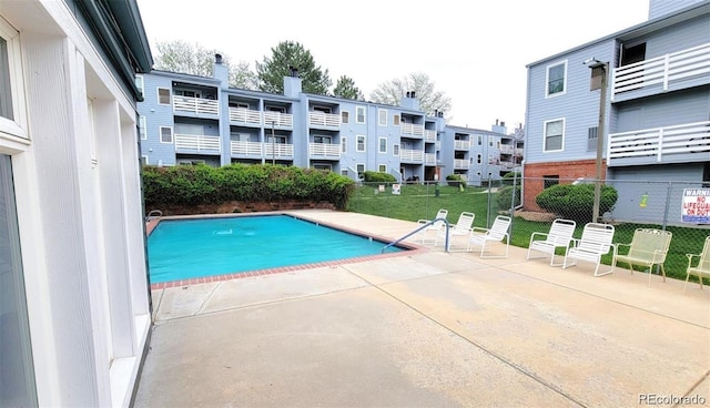 community pool with a patio and fence