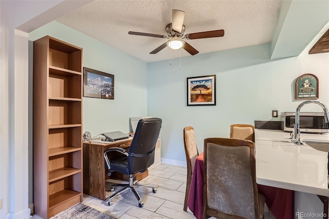 home office with ceiling fan, built in features, and a textured ceiling