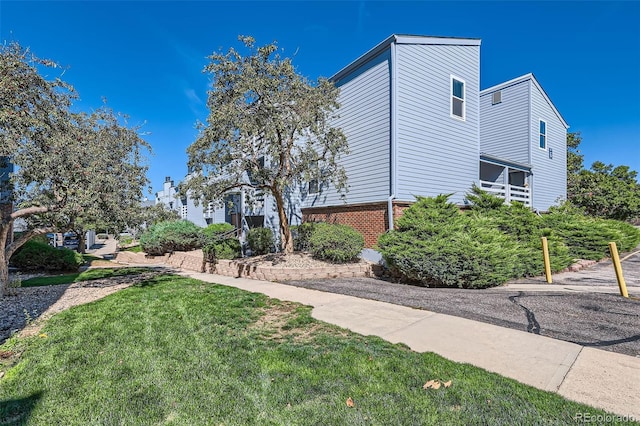 view of home's exterior featuring a yard and brick siding