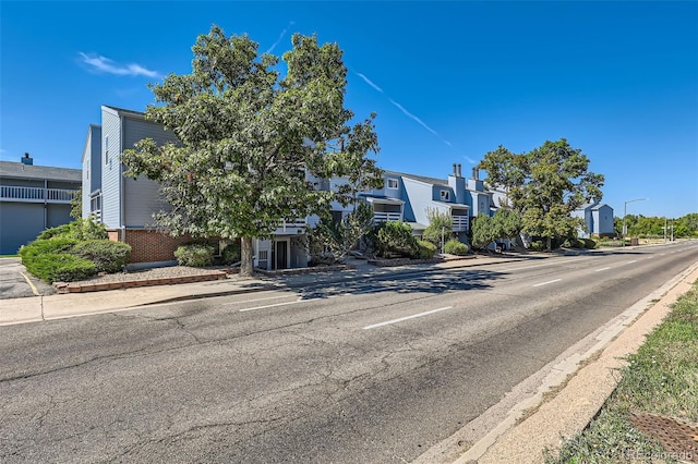 view of front of property with uncovered parking, brick siding, and a residential view