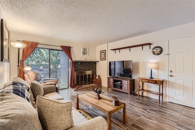 living room with a textured ceiling, a fireplace, and wood finished floors