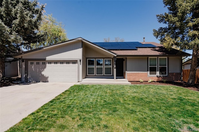 8559 W 75th Pl, Arvada, CO 80005 - view of front of home featuring brick siding, solar panels, a garage, and concrete driveway