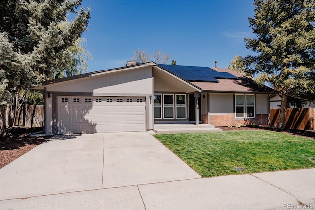 8559 W 75th Pl, Arvada, CO 80005 - view of front facade with a garage, brick siding, driveway, and roof mounted solar panels