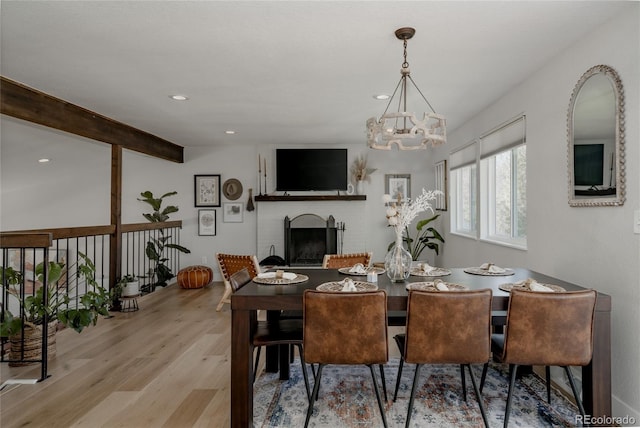 8559 W 75th Pl, Arvada, CO 80005 - dining space with a brick fireplace, wood finished floors, a chandelier, and recessed lighting