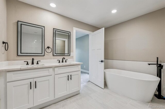 46 Douglas Dr, Broomfield, CO 80020 - bathroom with double vanity, a soaking tub, and recessed lighting