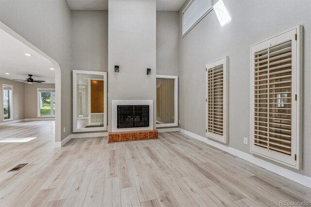 46 Douglas Dr, Broomfield, CO 80020 - unfurnished living room with a high ceiling, wood finished floors, ceiling fan, recessed lighting, and a fireplace with raised hearth