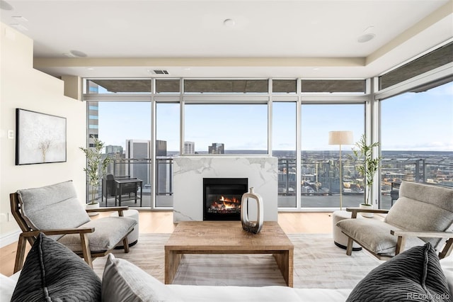 living area with a wall of windows, a city view, and wood finished floors