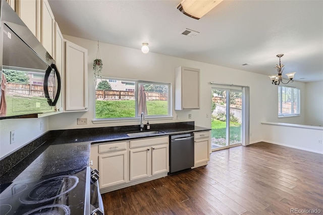 kitchen with decorative light fixtures, dark hardwood / wood-style flooring, a notable chandelier, stainless steel appliances, and sink