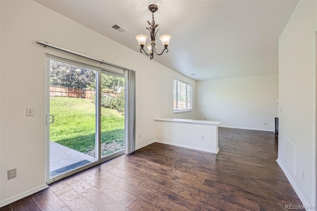 unfurnished room featuring dark hardwood / wood-style flooring, a notable chandelier, and a healthy amount of sunlight