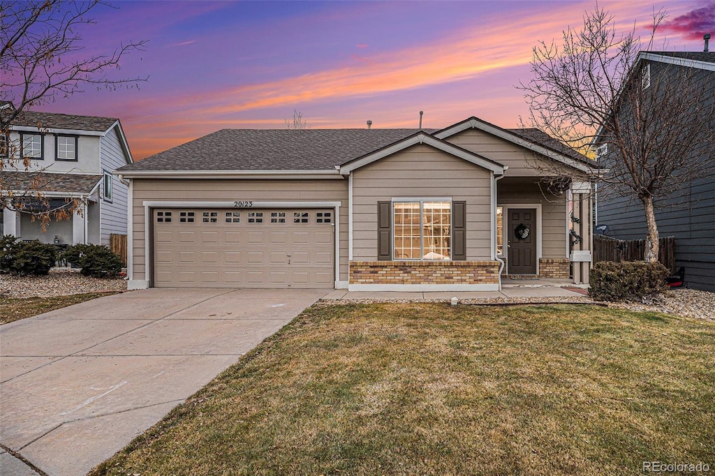 view of front of home with a garage and a lawn