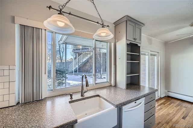 kitchen with gray cabinets, dishwasher, sink, and a healthy amount of sunlight