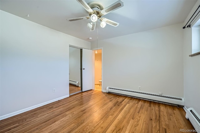 unfurnished bedroom with baseboard heating, ceiling fan, and light hardwood / wood-style flooring