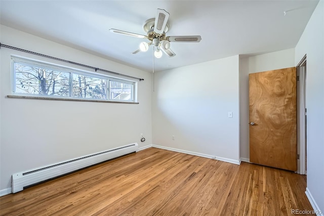 empty room featuring a baseboard radiator, light hardwood / wood-style floors, and ceiling fan