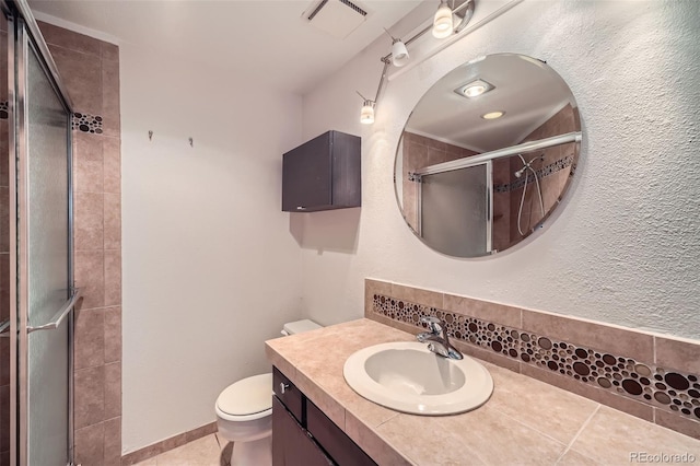 bathroom with walk in shower, vanity, tile patterned floors, and toilet