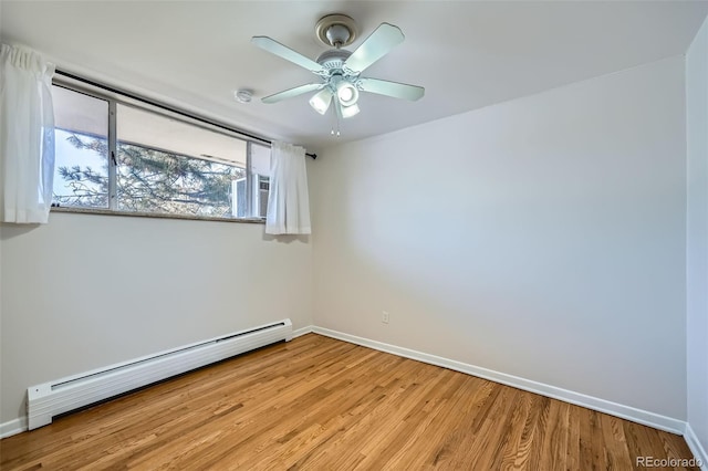 spare room featuring ceiling fan, a baseboard radiator, and light wood-type flooring