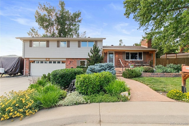 1615 Violet St, Golden, CO 80401 - split level home with brick siding, driveway, a garage, and a chimney