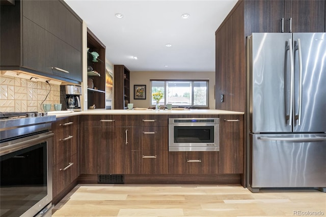 1615 Violet St, Golden, CO 80401 - kitchen with stainless steel appliances, a peninsula, backsplash, light wood finished floors, and dark brown cabinets
