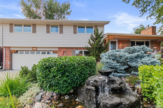 1615 Violet St, Golden, CO 80401 - split level home with brick siding, a garage, a chimney, and concrete driveway